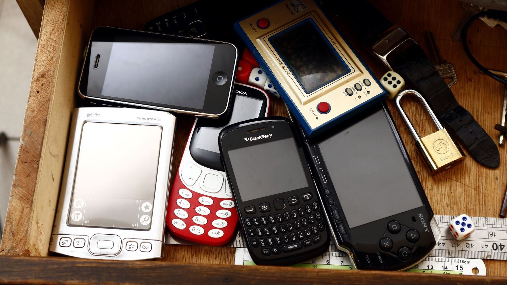 image of old mobile phones in a cupboard drawers