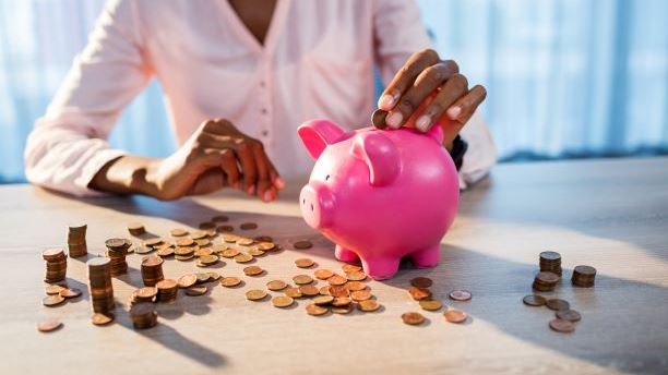 Person putting coins in piggy bank