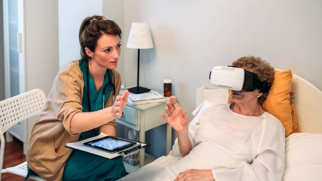 Older patient using virtual reality glasses to see her spine while female doctor explains