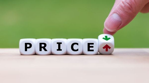 Hand is turning a dice and changes the direction of an arrow symbolizing that the price is going down