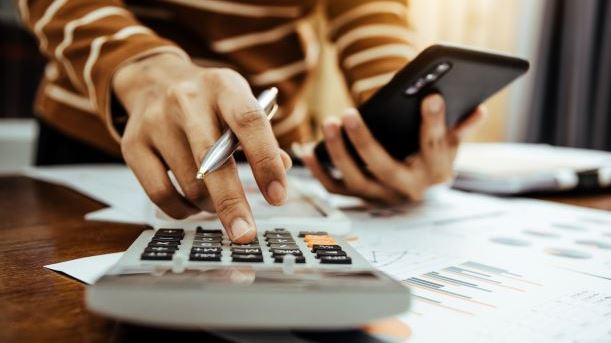 person typing on calculator