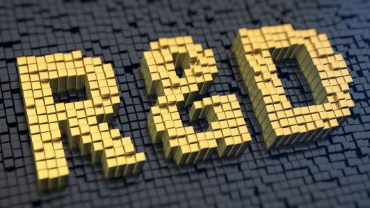 The letters 'R&D' in yellow bricks on a background of black bricks
