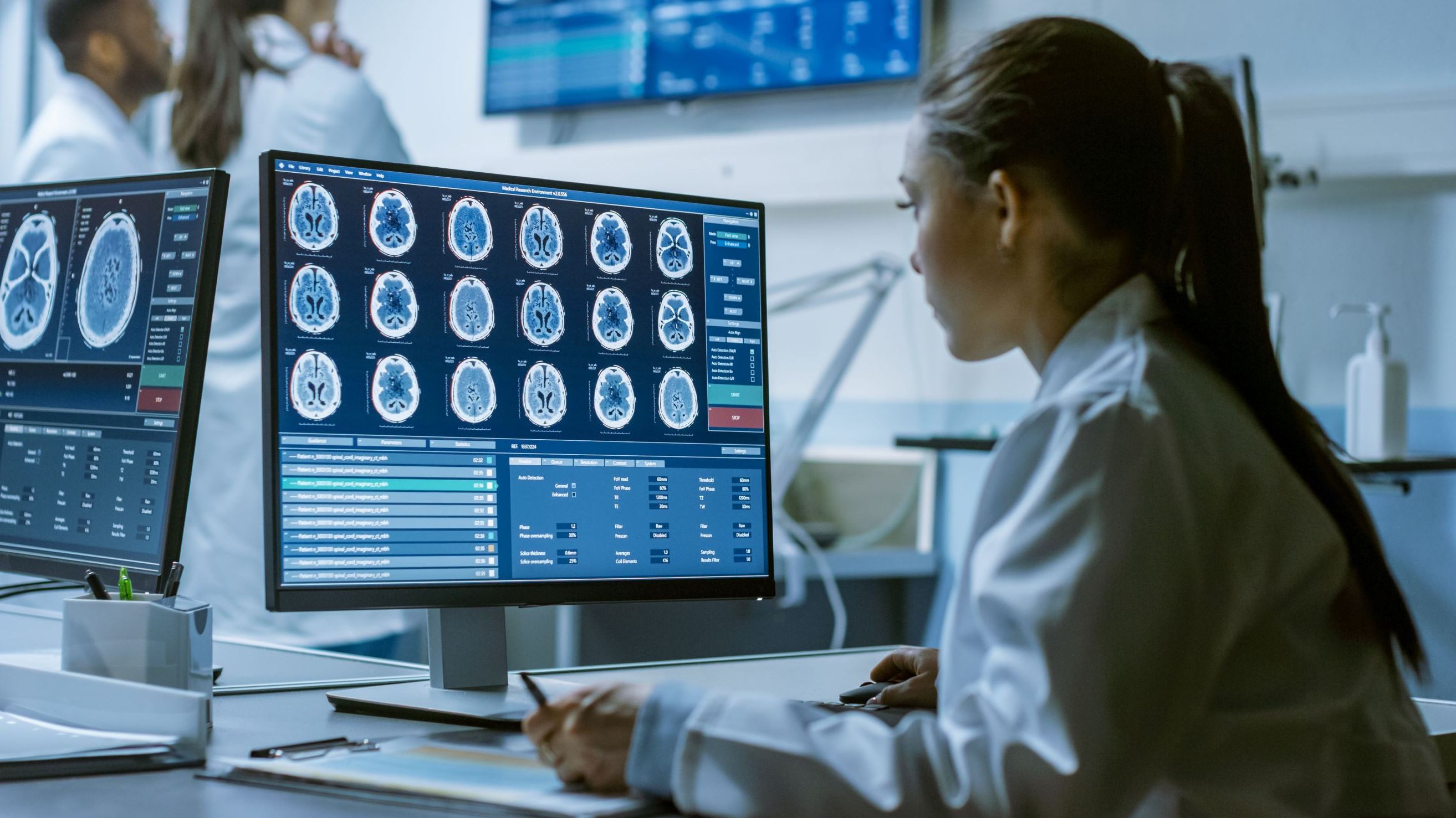 doctor looking at a brain scan in front of a computer