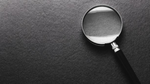 Magnifying glass on grey background