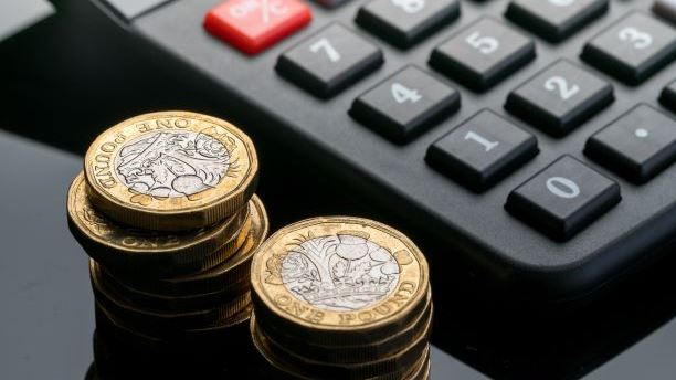 Pound coins next to a calculator