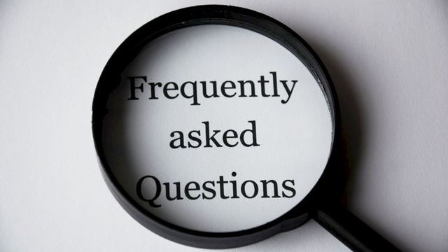The words 'frequently asked questions' typed on a page with a magnifying glass over it
