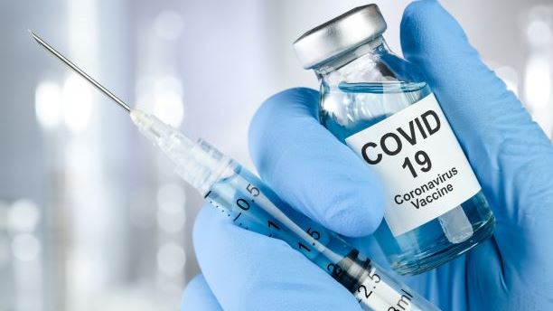COVID-19 Vaccine in syringe being held