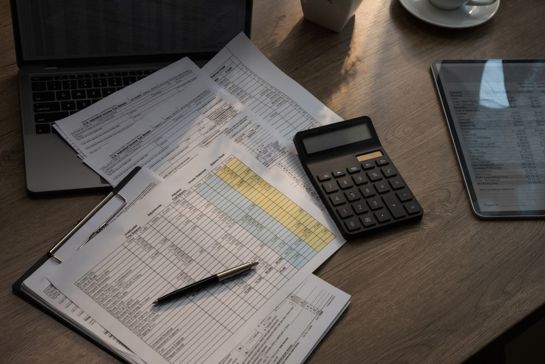 Calculator, Spreadsheet, Laptop And Tablet On Desk